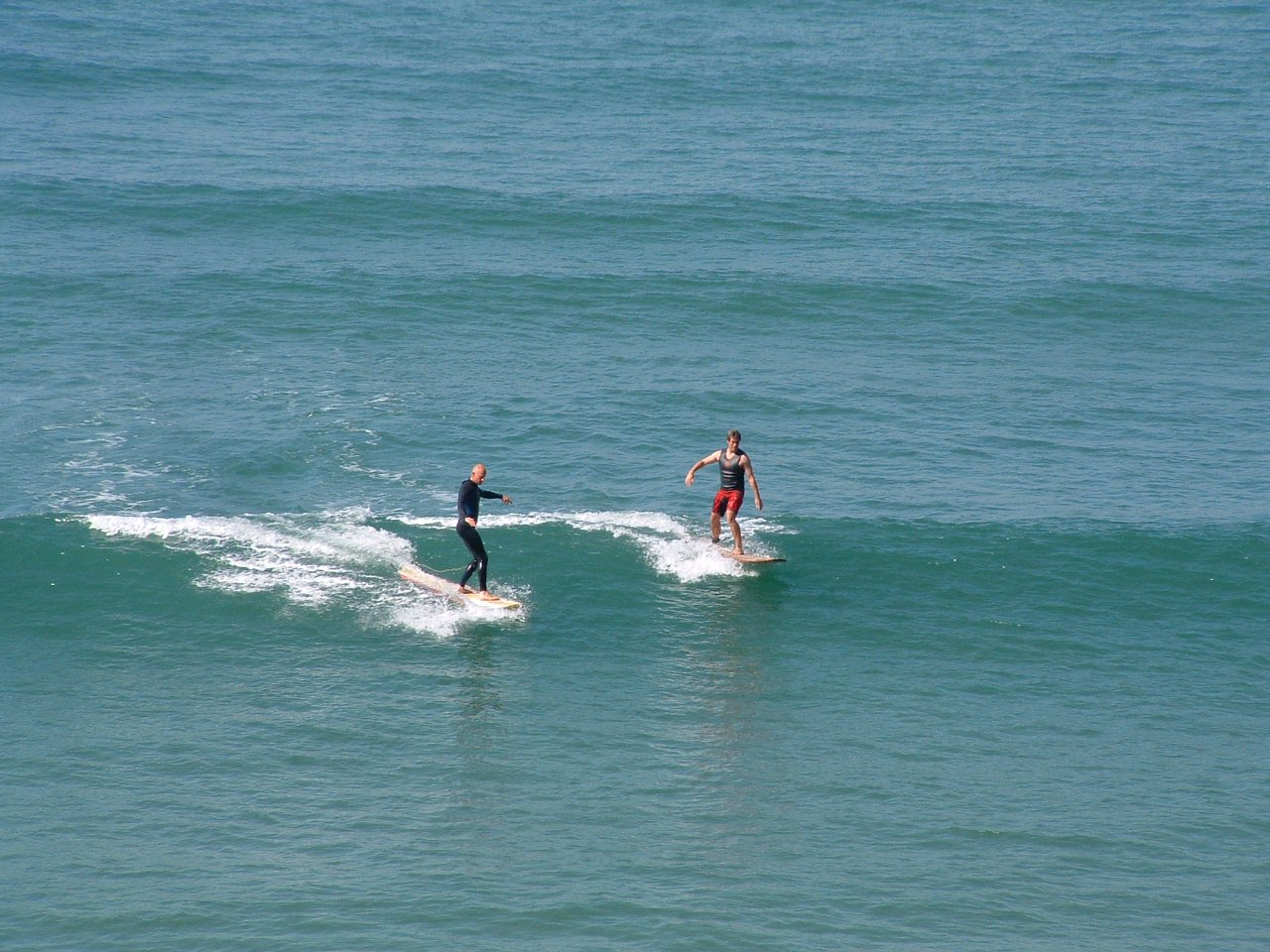 an old photo of two people surfing